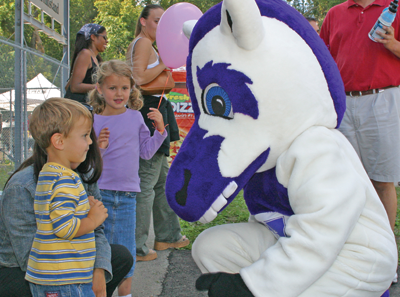 Western's Mustang mascot talking to a child