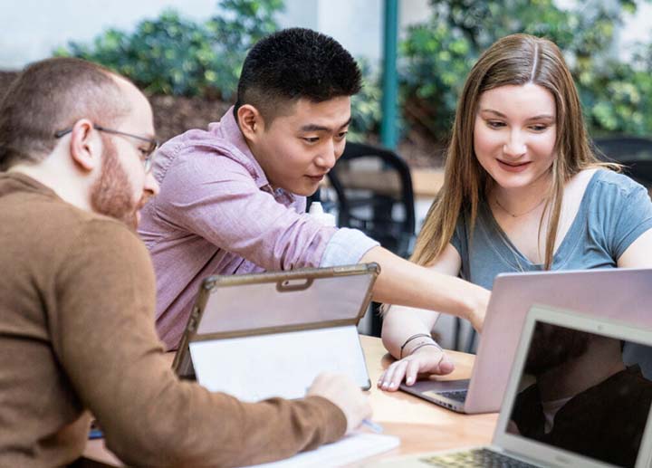 Students pointing to a laptop